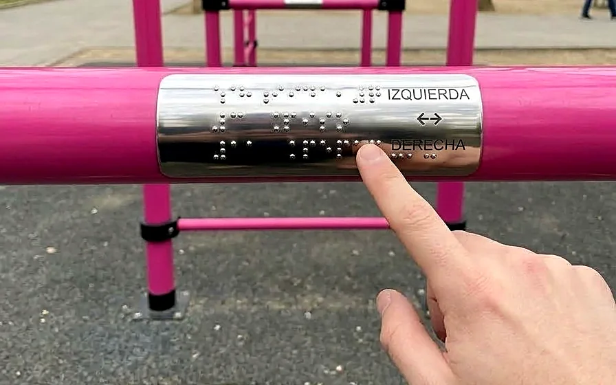 Placa de acero con braille en relieve e indicación IZQUIERDA / DERECHA sobre una barra rosada