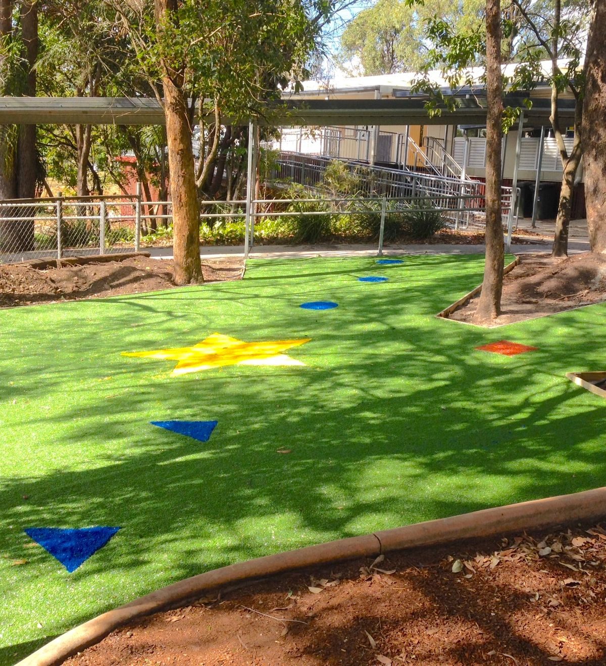 Patio con piso de seguridad Funny Grass y figuras de colores